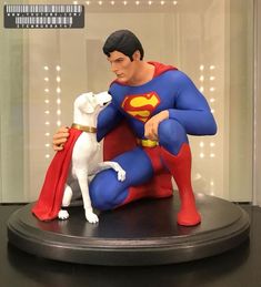 a statue of superman and his dog in a display case