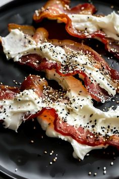 bacon and eggs on a black plate with sprinkles