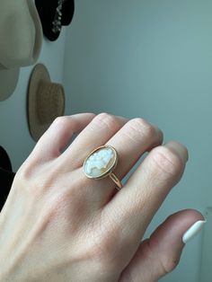 Vintage 10k Bezel Carved Natural Shell Cameo Ring Description: This vintage 10k ring features a carved natural shell cameo set in a bezel, adding a unique touch to your collection. Sized at 8 and weighing 4.31g, the shell's unique tone makes this ring a standout piece. As with all our pieces, this ring is a rare find—once it's gone, it's gone. Choosing this piece helps you stand out from the crowd while supporting sustainable practices. Why You'll Love It: Unique Design: The carved shell cameo a Classic Oval Cameo Rings, Classic Oval Cameo Jewelry, Fine Jewelry Cameo Round Jewelry, Cameo 14k Gold Round Jewelry, Gold Cameo Ring Jewelry, Antique White Oval Cabochon Jewelry, 14k Gold Cameo Round Jewelry, White Oval Cameo Jewelry, Cameo Fine Jewelry Rings