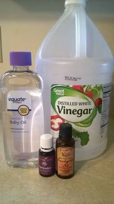 bottles of vinegar and baby oil sitting on a counter