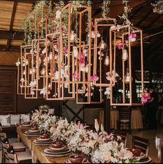 a long wooden table topped with lots of plates and place settings covered in pink flowers