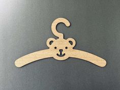 a wooden hanger with a teddy bear on it