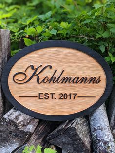 a wooden sign that says kohlman's est 2017 on it in front of some trees