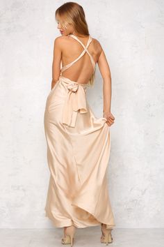 The Mind And Memory Maxi Dress has a smooth, silky fabric that glides over the body. A plunging v-neckline is secured with long halter-neck ties that fall gracefully over an exposed back. A hidden back zipper with a hook and eye closure holds the dress in at the waist. We love this dress with delicate gold jewellery! Maxi dress. Not lined. Cold hand wash only. Model is standard XS and is wearing XS. True to size. Slightly stretchy fabric. Polyester. Satin Dresses With Lace-up Low Back, Satin Halter Dress With Tie Back For Date Night, Satin Maxi Dress With Tie Back, Strappy Back Maxi Dress With Back Opening For Spring, Spring Maxi Dress With Strappy Back Opening, Elegant Halter Dress With Bow Tie Back For Evening, Spring Formal Backless Dress With Tie Back, Prom Halter Maxi Dress With Tie Back, Formal Low Back Dress With Tie Back