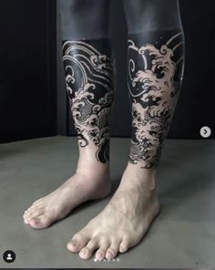 the legs and ankles of a man with tattoos on his body are covered in black ink