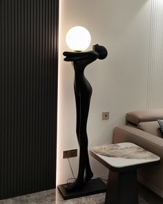 a lamp that is on top of a table in a living room next to a couch