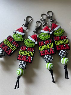 the grinch era keychains have been made to look like they are wearing santa's hats