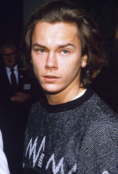 a young man with long hair wearing a sweater