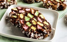 some cookies are on a white plate with green and pink toppings