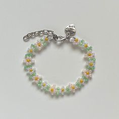 a beaded bracelet with an elephant head charm on the front and back ends is shown in green, yellow, and white beads