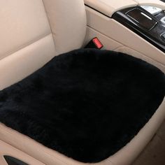 the interior of a car with a black sheepskin seat cover