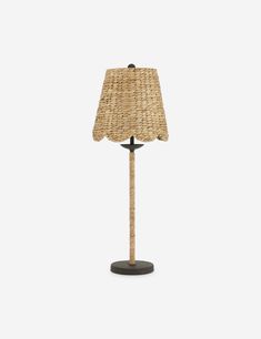 a lamp that is made out of wicker and has a shade on the base