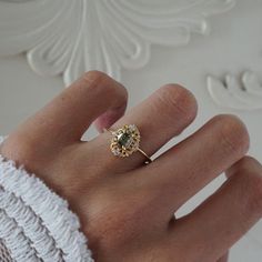 a woman's hand with a yellow diamond ring on top of her left hand