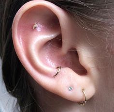 a close up of a person's ear with two piercings