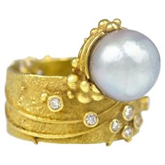 A vintage handmade and unique pearl, diamond and textured 18 karat yellow gold ring, by Gerda Flöckinger, United Kingdom, c. 1970. Signed GF. Ring is a size 6.25 and measures 0.70" x 0.38" x 0.40". The ring is work of art, poetic and radiant. The craftsmanship is superb with the conventional marriage of diamonds and pearls set aside for a newer more modern arrangement in 1970. Certainly a forever ring by a renowned maker. Even an engagement ring? A leader of the avant garde modern jewelry movement in London during the 1960s, Gerda Flockinger has long been regarded as the one of the greatest British modern artist jewelers. She was born in 1927 in Innsbruck, Austria and immigrated to England in 1938. The modern 1970s pearl and gold band ring available here displays the touch of Art Nouveau t Gerda Flockinger, First Ladies, Art Jewelry Contemporary, Isabel Ii, Innsbruck, 18k Gold Ring, Gold Band Ring, Pearl Set, Sterling Silver Bangles