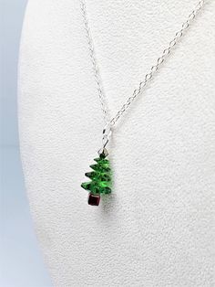 Christmas tree pendant necklace in classic Fern Green featuring genuine Swarovski Crystals top to bottom.  Finished with an 18-inch Sterling Silver rolo chain.  Pendant measures 1 inch long and 1/2 inch wide.  Celebrate the holidays in glamorous style with this super sparkly necklace.  Makes the perfect Christmas gift for women, and a brilliant gift for you.  Why not treat yourself!?  🎁 Arrives in a gift box with bow, ready for giving. 🎁   📦  All orders are shipped via USPS with tracking. Holiday Sterling Silver Necklace, Sterling Silver Necklaces For Christmas, Christmas Holiday Pendant Necklaces, Christmas Sterling Silver Jewelry, Green Necklace Christmas Gift, Christmas Holiday Pendant Necklace, Christmas Tree Necklace, Christmas Gift For Women, Crystal Christmas Tree