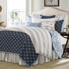 a bed with blue and white comforters in a room