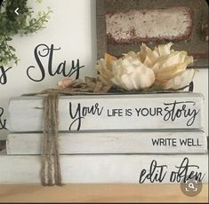 three books stacked on top of each other with flowers in the middle and one book that says, stay strong your life is your story write well eat often