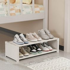 there are many pairs of shoes on the shelf in front of the bunk bed that is built into the floor