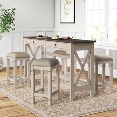 a dining table with four stools in front of it