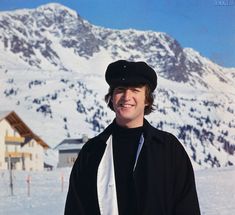 a man standing in front of a snow covered mountain