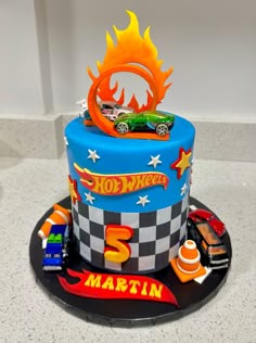 a birthday cake decorated with cars and flames