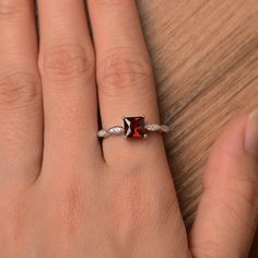 It is a natural garnet ring, princess cut, measures 6mm*6mm, weight about 1.51 cts. The basic metal is sterling silver and plated with rhodium. To change the metal to a solid gold (white/rose) or platinum is also available, please ask for a quotation if you want. You can also go to my shop Home for more elegant rings: https://www.etsy.com/shop/godjewelry?ref=hdr_shop_menu garnet is January birthstone More garnet rings: https://www.etsy.com/shop/godjewelry?ref=seller-platform-mcnav&section_id Garnet Emerald Cut Promise Ring, Emerald Cut Garnet Promise Ring, Square Cut Ruby Jewelry Fine Jewelry, Princess Cut Jewelry With Accent Stones, Gift Ruby Princess Cut Ring, Princess Cut Ruby Rings Suitable For Gift, White Gold Garnet Jewelry For Promise Ring, Princess Cut Ruby Ring Gift, Red Princess Cut Rings With Center Stone