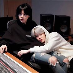 two people sitting in front of a mixing desk