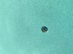 an aerial view of the ocean with a shell in the sand and blue water behind it