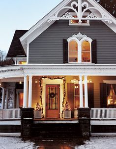 a house decorated for christmas with lights and wreaths on the front porch is lit up