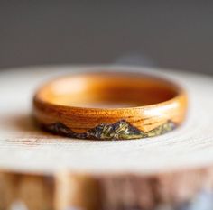 a wooden ring sitting on top of a piece of wood