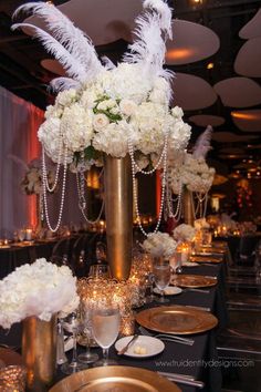 the centerpieces are adorned with white flowers and feathers