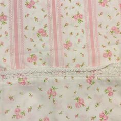 pink roses and white lace are on the bottom of this bedding set, which has been made in england