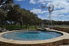 an outdoor hot tub with a windmill in the background