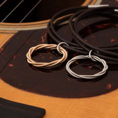 Indulge in the elegance of music with our Guitar String Twist Necklace. Made from played acoustic guitar strings, this necklace adds a twist to your daily style. The circular design represents endless melodies, while the black rubber lacing adds a touch of simplicity. A must-have for any music lover. Guitar String Jewelry, Twist Necklace, String Jewelry, Electric Guitar Strings, Eco Luxury, Acoustic Guitar Strings, Heart Strings, Circular Design, Gold Jewelry Necklace