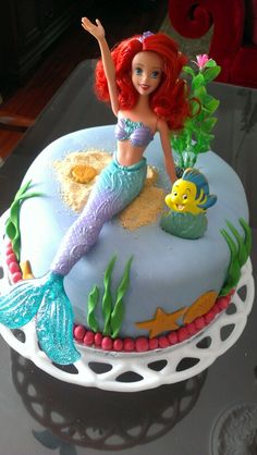 there is a cake with a little mermaid on it