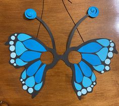 a blue butterfly with white dots on it's wings is hanging from a string