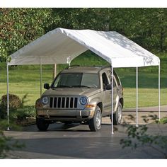 a jeep parked in front of a white tent on the side of a road with trees and grass behind it