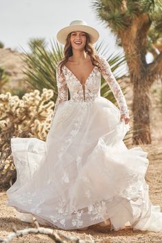 a woman in a white dress and hat is walking through the desert with palm trees