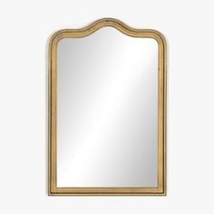 a mirror that is sitting on top of a white wall and it has a gold frame