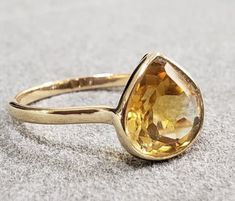 Features -  1. Citrine 14k Gold Ring 2. Made to Order 3. Total weight - 1.960 Gram 4. Citrine Weight - 2.65 Carats 5. Gold Purity - 14k  6. Gold Weight  - 1.430 Grams Approx. 7. Citrine Size - 9.50x9.50 MM 8. Band width - 1.60 mm 9. 1 Quantity Available 10. Setting - Bezel  11. Ready to dispatch in 1  - 2 days. - We have recently made this and couldn't resist of sharing this exclusive and stunning 2 stone ring with you. We bet! You will surely love our craftsmanship. -Quality is guaranteed. Our mission is always to satisfy our customers with our offerings, so just relax and place order! -And apart from this those who are looking lesser price rings we have an amazing offer in gold diamond jewelry. For this contact us directly. -Handling time is 1 - 2 days. -Various designs are available so Fine Jewelry Yellow Gold Topaz Ring With Teardrop, Yellow Gold Teardrop Sapphire Ring, Yellow Gold Teardrop Gemstones For Anniversary, Anniversary Yellow Gold Teardrop Gemstones, Formal Yellow Gold Topaz Teardrop Ring, Anniversary Yellow Gold Teardrop Topaz Ring, Teardrop Sapphire Ring In Yellow Gold For Gift, Pear Shaped Yellow Gold Rings For Gift, Heirloom Yellow Gold Pear Shaped Ring