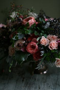 a vase filled with lots of flowers on top of a table