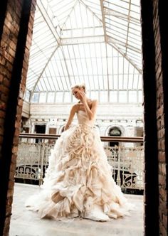 a woman in a wedding dress is posing for the camera