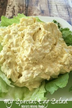 a salad with lettuce and mayonnaise on it is sitting on a white plate