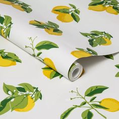 a white wallpaper with lemons and green leaves on the outside, as well as a roll of tape