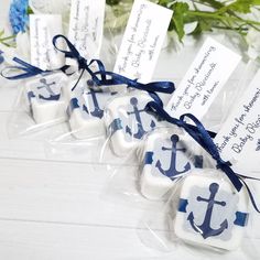 some white chocolates with blue anchors on them and tags tied to the top of them