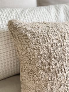 two white pillows sitting on top of a bed