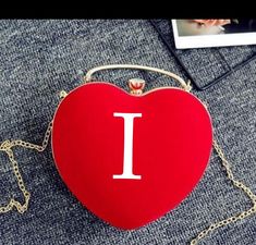 a red heart shaped purse with the letter l on it