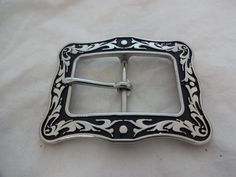 A new buckle from Horse Shoe Brand Hardware, designed by Jeremiah Watt. A stainless steel square buckle in the black Floral pattern.The measurements reflect the size of material that the buckle and tip will fit on to (the length measured from inner edge to inner edge).  For example, the 1 1/2" set will fit an 1 1/2" wide piece of material. Classic Black Belt Buckles With Silver Buckle, Classic Black Concho Belt Buckles, Classic Black Rectangular Belt Buckles, Western Black Belt Buckles With Silver Detail, Western Black Belt Buckles With Silver Buckle, Black Western Belt Buckles With Silver Buckle, Black Floral Pattern, Western Belt Buckles, Western Belt