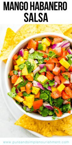 mango habanero salsa in a white bowl with tortilla chips on the side